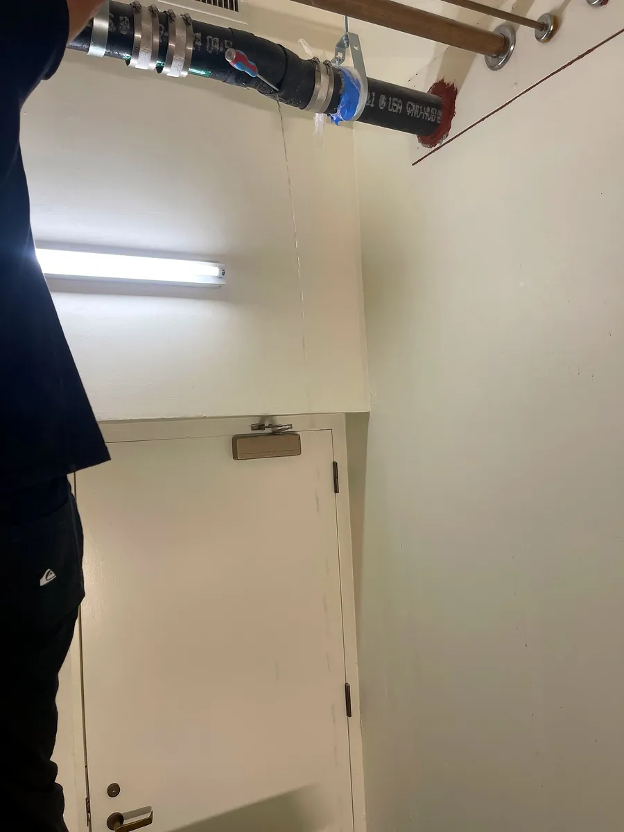 AB Plumbing technician replacing a cast iron bend above a hallway ceiling in Palo Alto