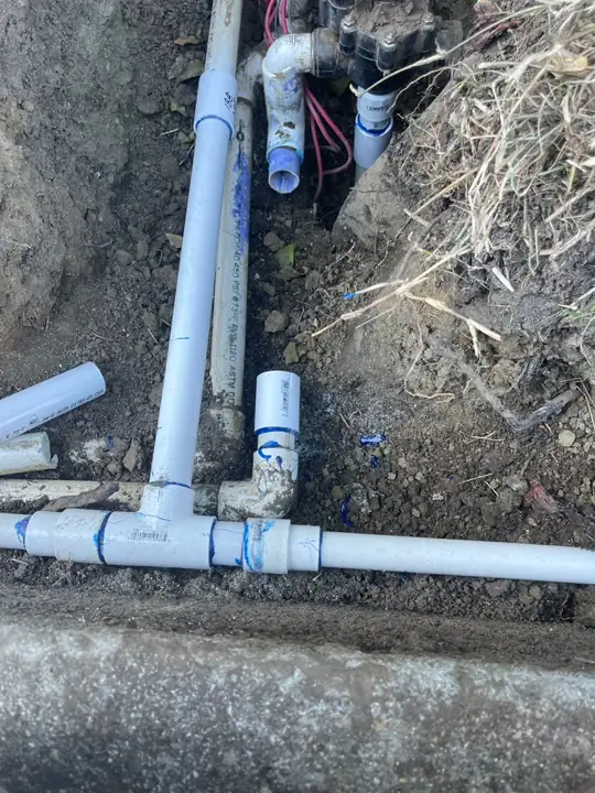 New PVC tee fitting on a sprinkler main line during a commercial replacement