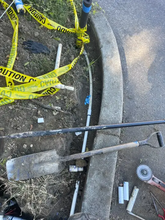 Trench along a curb for an underground irrigation water line repair