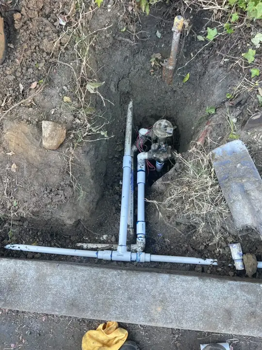 Underground water line and sprinkler valves in an open hole during repair